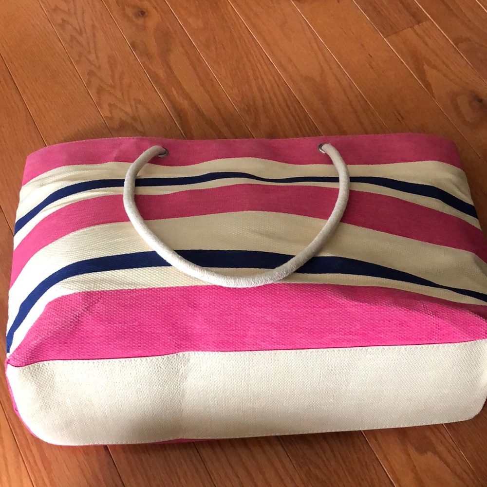 Bright pink and navy blue striped straw beach bag.